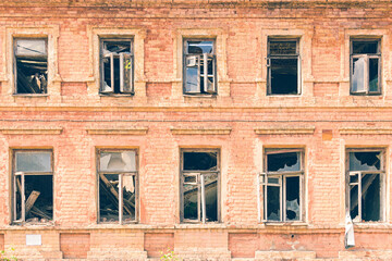 Collapsed roof and broken windows in an old brick building. Abandoned residential building