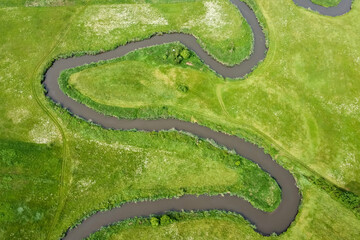 Fototapeta premium Aerial view landscape of winding river in green field.