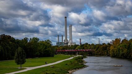 Obraz premium Blick über einen Fluss auf ein Heizkraftwerk in der Stadt