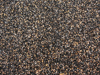 Beige-black-white stone gravel background texture. Brown small rocks abstract road pavement pattern