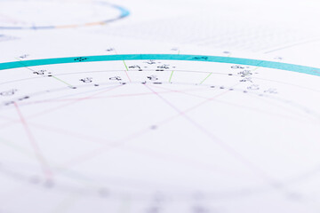 The desktop of an astrologer. The magical mysterious atmosphere of the working environment of the predictor of the future. Printouts of astrological charts and tables scattered across the table.