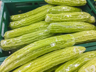 Pile of chinese bitter melon (Momordica charantia) for retail sale in Thailand fresh food supermarket. Momordica charantia also known as balsam apple, balsam pear, bitter cucumber, bitter gourd.