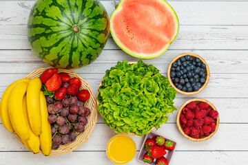 Group Fruits mixed and vegetables with salad bowl, nuts bowl, strawberry, banana, and pineapple, orange juice,  vitamin c in food  nature for health and diet in the top view on the wood table.