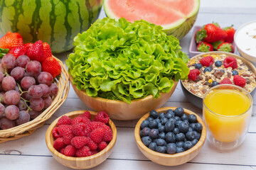 Group Fruits mixed and vegetables with salad bowl, nuts bowl, strawberry, banana, and pineapple, orange juice,  vitamin c in food  nature for health and diet in the top view on the wood table.