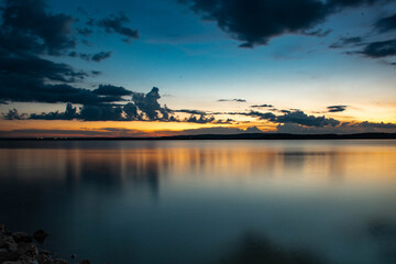 Smooth Reflective Sunset on Lake Water 