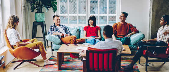 Happy adult diverse friends having nice conversation during discussion of startup project at home