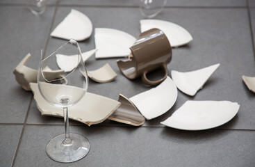 Broken Plate or broken water glass and dishes on the floor in the kitchen room The concept of accidents in the kitchen is dangerous for the body and young children inside the house.