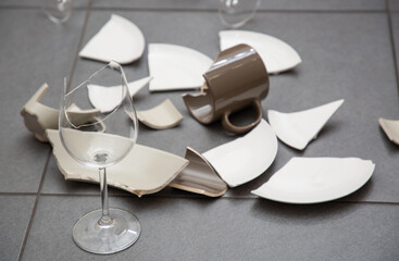 Broken Plate or broken water glass and dishes on the floor in the kitchen room The concept of...