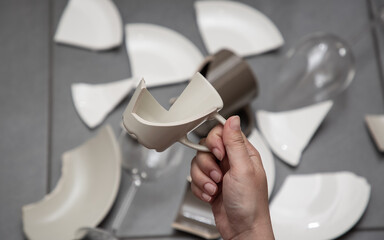 Broken Plate or broken water glass and dishes on the floor in the kitchen room The concept of accidents in the kitchen is dangerous for the body and young children inside the house.