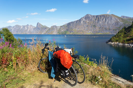 Two bicycles on the background of the sea and mountains on the island of Senja Norway. Camping on bicycles. Summer sunny day.