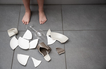 Broken Plate or broken water glass and dishes on the floor in the kitchen room The concept of...