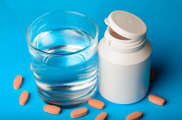 Pills in bottle on blue background 