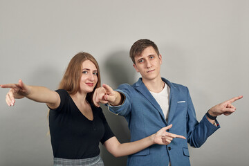 Hand pointer with forefinger pointing forward. Index finger to show direction. Means choosing, introducing too. Indicating towards. Young attractive couple boyfriend girlfriend two people