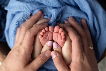 little feet a newborn baby boy. Legs on blue background, ,soft focus