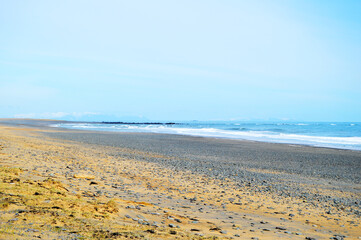 Amazing lonely and wavy beach with sand and rocks