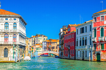 Fototapeta na wymiar Venice Grand Canal waterway cross Cannaregio Canal with Palazzo Labia palace, Ponte delle Guglie bridge and colorful buildings, blue clear sky background in summer day, Veneto Region, Italy