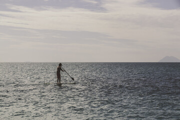 Man and sup-surfing. Sup surfing on the sea in Italy on the Sicily.