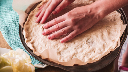 Homemade pizza with mozzarella and ham with basil. On a wooden table top.