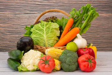 Group Healthy assorted fresh vegetable in a wooden basket, With vitamins c from salad, tomato, carrot, Cauliflower, and ginger, Is good for the body and diet food on  table in the nature  background.