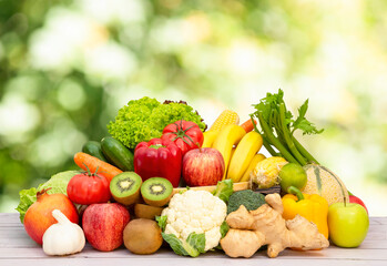 Assortment of Fresh vegetables and fruits With vitamins c from bananas, kiwi, grapes, raspberries, blueberries, and blackberries, good for the body and diet food on the table in nature background.