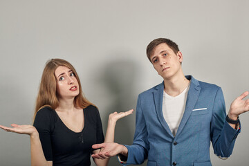 Confused mood spreads hands wide with doubt face. Shock. People sincere emotions. Widely divide arms in disbelief, disappointment and misunderstanding. Young attractive couple boyfriend girlfriend