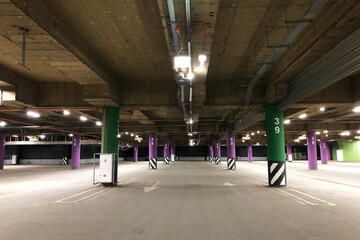 empty underground parking lot on basement of shopping mall. No cars, no people. Closed supermarkets due to quarantine lockdown. Extreeme safety measures.