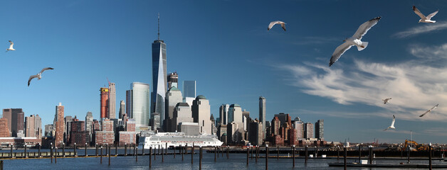 Panoramic view of Manhattan skyline with cruise liner leaving the port and gulls. New York. USA.