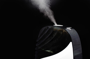 Humidifier on a black background. Humidifier overall plan and macro. The device is face and sideways. Steam water in macro. Black navigation bar, humidifier controls white touch mode keys