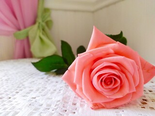 Pink rose on the white tablecloth