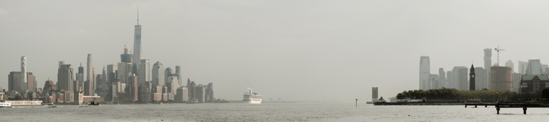Obraz premium Panoramic view of foggy Manhattan and Jersey City skiline with white cruise liner passing by. New York. USA.