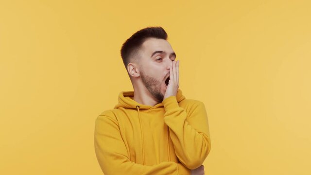 Expressive young man over vibrant background. Studio portrait of borred person.