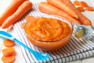 Composition with carrot puree on white wooden background. Baby food