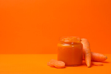 Composition with vegetable puree on orange background. Baby food