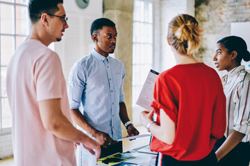 Adult diverse business partners consulting with expert during conference in loft spacious office