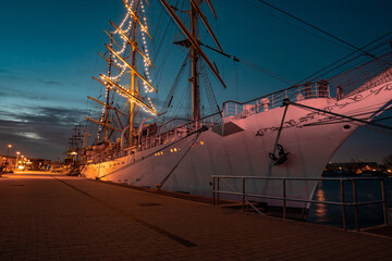 Beautiful sailing boat moored to the port, illuminated by Christmas tree-shaped lights. Gdynia...
