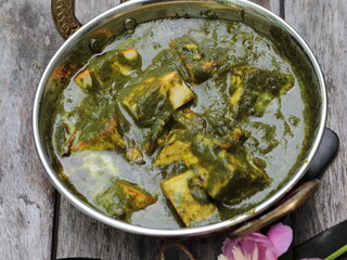 A bowl of Palak Paneer made of Paneer cheese dipped in mildly spiced Spinach gravy.