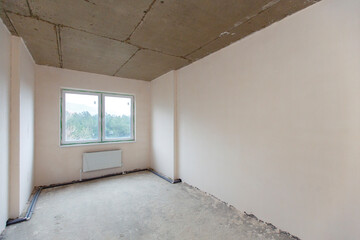 A small room that hasn't been finished yet. The non-renovated rooms. New building. The walls are plastered, the floors are concreted. There is a posting