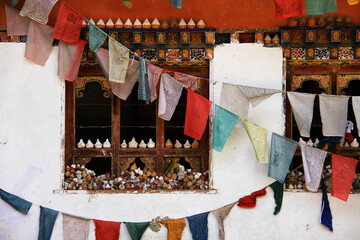 roadside buddhist memorial with prayer flags and tsa-tsa