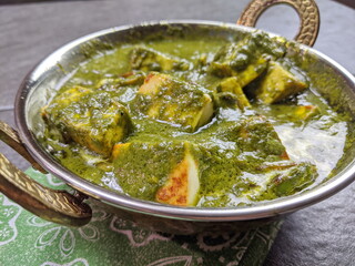 A bowl of Palak Paneer made of Paneer cheese dipped in mildly spiced Spinach gravy.
