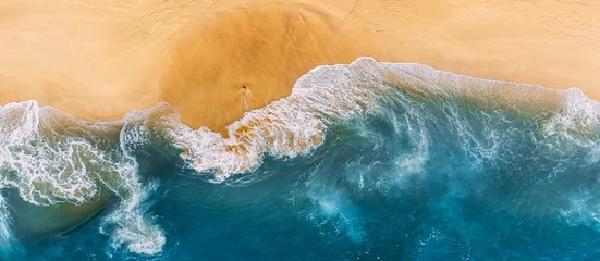 Fototapeten Aerial view of blue ocean waves in Kelingking beach, Nusa Penida island in Indonesia. Beautiful sandy beach with blue sea. Lonely sandy beach with beautiful waves. Beaches of Indonesia. Copy space © MISHA
