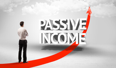 Rear view of a businessman standing in front of PASSIVE INCOME inscription, successful business concept