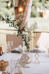table number and white flowers on the white festive table. Table number 2