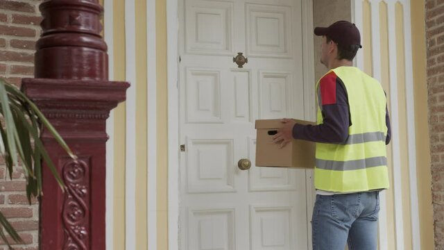 delivery man delivers the parcel at home