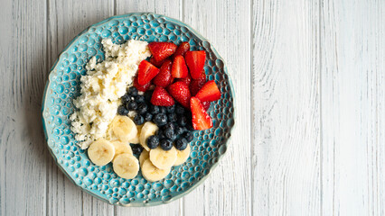 Healthy summer breakfast. Cottage cheese with strawberry blueberry banana and honey. Beautiful breakfast