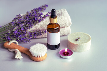Spa products, soap, face brush and towel, lavender flowers on white background