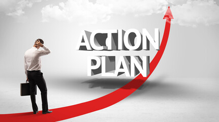 Fototapeta premium Rear view of a businessman standing in front of ACTION PLAN inscription, successful business concept