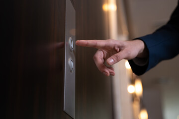 Male index finger going to press elevator button