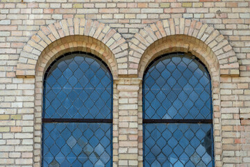 Obraz premium Old vintage window on a brick building. Arched windows on the church.