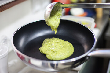 A process of making green vegetable pesto sauce on a pan