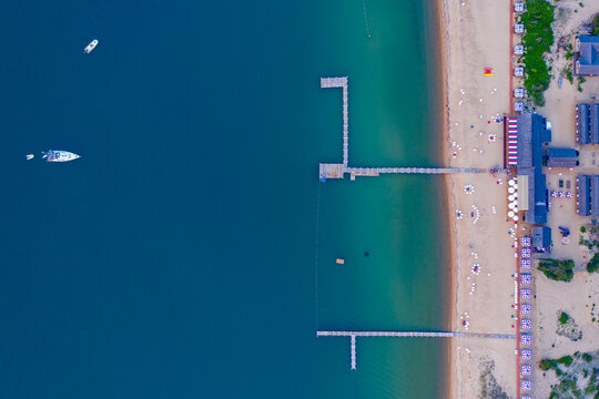 Aerial top-down view of a beach with piers and turquoise water on Chappaquiddick, Martha's Vineyard, Massachusetts